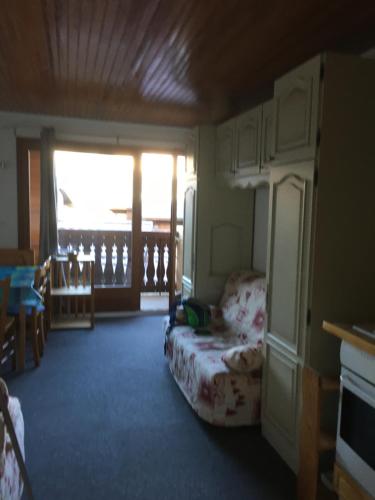 a room with a bedroom with a bed and a balcony at Appartement Cosy in Les Carroz d'Araches