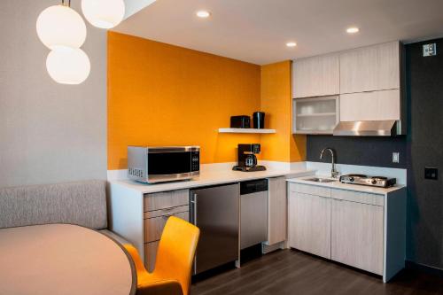 a small kitchen with yellow walls and a table at Residence Inn by Marriott Calgary Downtown/Beltline District in Calgary