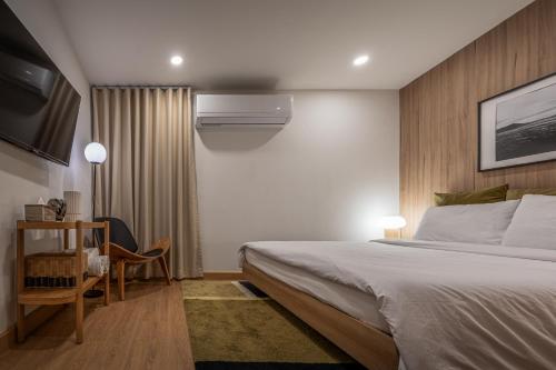 a bedroom with a bed and a desk and a tv at 2 Bed 2 Bath / Luxury / 1 min walk to BTS Asok in Bangkok