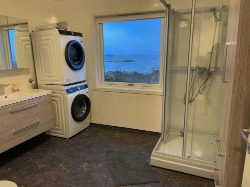 y baño con ducha y lavadora. en Hokland Panorama, en Ånstad