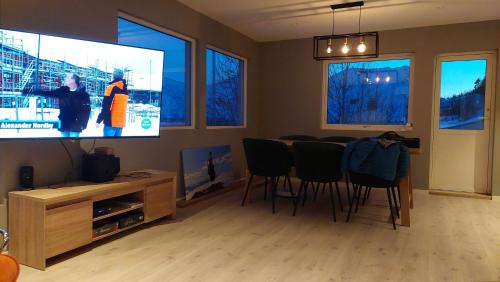 a living room with a tv and a table and chairs at Senja 4 Summit in Torsken