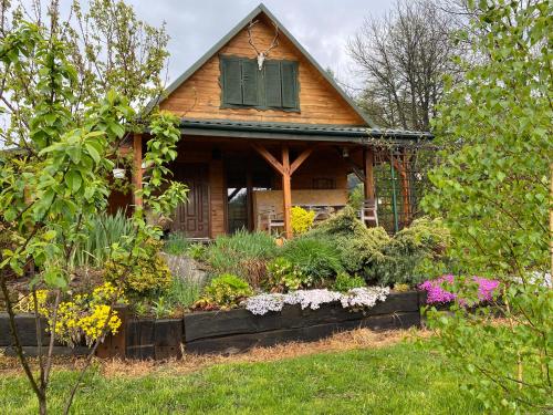 a house with a flower garden in front of it at Jaśminowy ogród in Brenna