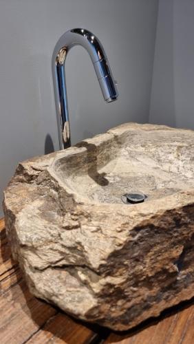 un évier en pierre avec un robinet d'eau sur un comptoir dans l'établissement Pedra Pura Resort, à Chaves