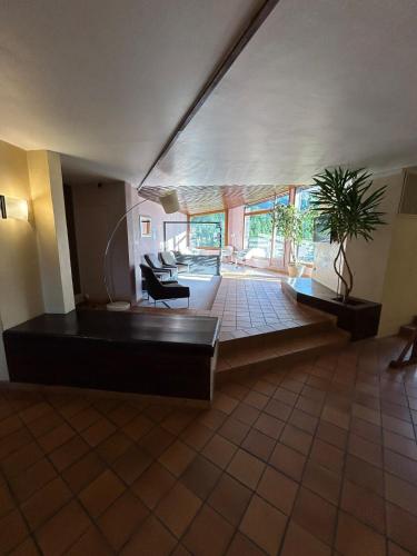 un grand salon avec un canapé et une plante dans l'établissement Studio 4 personnes les Orres vue sur le lac, aux Orres