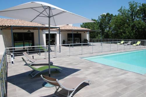 un patio avec des chaises et un parasol à côté d'une piscine dans l'établissement Près d'Avignon villa de rêve piscine, à Saint-Geniès-de-Comolas