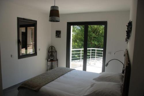 une chambre avec un lit et une grande fenêtre dans l'établissement Près d'Avignon villa de rêve piscine, à Saint-Geniès-de-Comolas