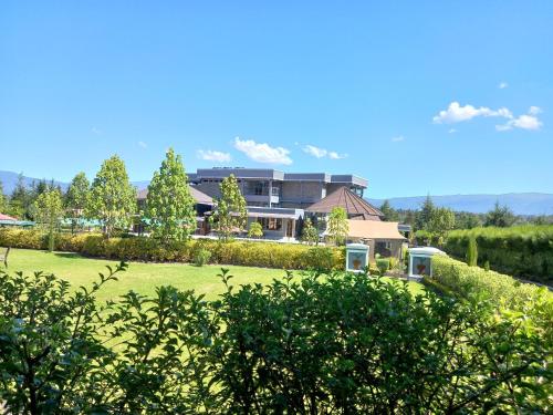 a house in a field with a large yard at Olempiaus Gardens Hotel in Mai Mahoro