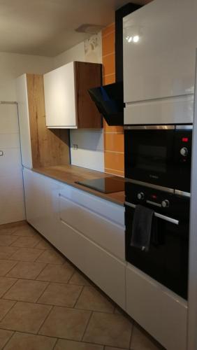 - une cuisine équipée d'un four avec plaques de cuisson en noir et blanc dans l'établissement Maison proche mer - 5 couchages - ideal planchistes, à Lapalme