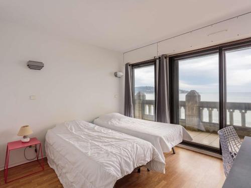 une chambre avec deux lits et une grande fenêtre dans l'établissement Appartement moderne en bord de mer avec balcon et parking - FR-1-2-306, à Hendaye
