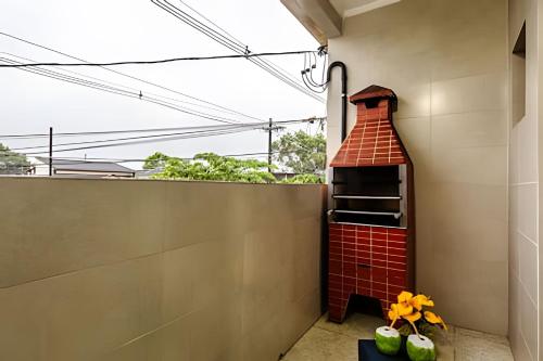 einem Steinkamin an der Seite eines Gebäudes in der Unterkunft Casa de condomínio HP2 - Ideal para turistas e empresas - 7 min de carro das praias Tupi e Ocian in Praia Grande