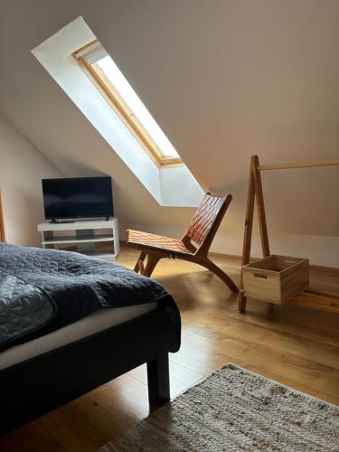 a bedroom with a bed and a tv and a chair at Tatraview House in Veľká Lomnica