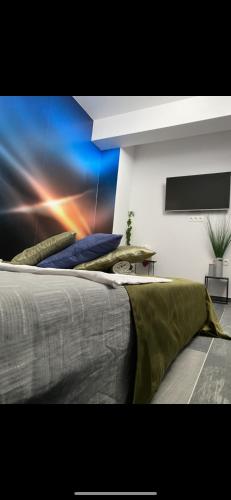 a bedroom with a large bed with a painting on the wall at O5 residence in Nivy