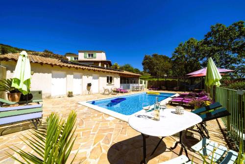 une terrasse avec une table et des chaises blanches ainsi qu'une piscine dans l'établissement Résidence Au Brin d'Olivier, à Saint-Martin-dʼArdèche