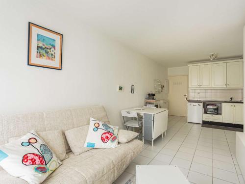 un salon avec un canapé et une cuisine dans l'établissement Appartement à 200 m de la plage avec terrasse et parking, au cœur des commerces et restaurants - FR-1-2-426, à Hendaye