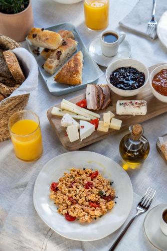 a table with a plate of food and bread and orange juice at Eat well Sleep Well in Larnaca