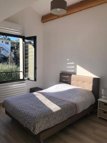 une chambre avec un lit et une fenêtre dans l'établissement Sublime haut de villa aperçu mer /hippodrome /, à Cagnes-sur-Mer