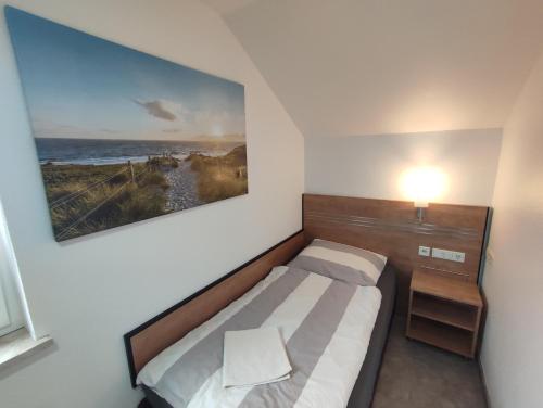 巴特拉珀瑙My-Skypalace Bad Rappenau的卧室里有一张床，墙上挂着一幅画