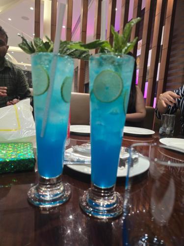 two glasses of blue drinks sitting on a table at HOTEL PARADISe in Guwahati
