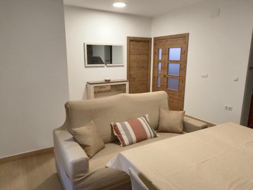 a living room with a couch and a television at Apartamentos La Fuente in Almodóvar del Río