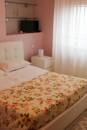 a bedroom with a bed with a floral bedspread at B&B Il Panorama in Torremaggiore