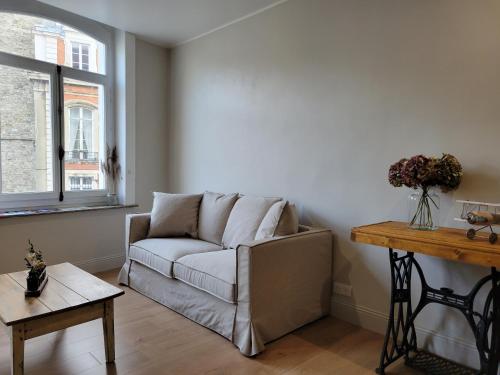 un salon avec un canapé et une table dans l'établissement La suite du vieux Boulogne - Appartement au cœur de la vieille ville avec vue directe sur le beffroi, à Boulogne-sur-Mer