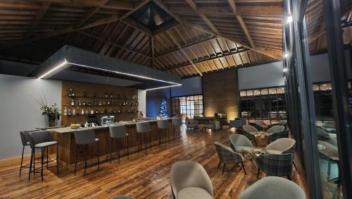 a restaurant with a bar with chairs and tables at Pedra Pura Resort in Chaves