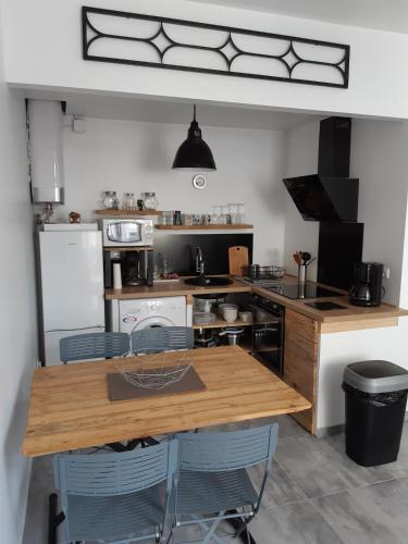 une cuisine avec une table en bois et des appareils électroménagers dans l'établissement Le Reposant by Tranquil at Home, à Pornichet