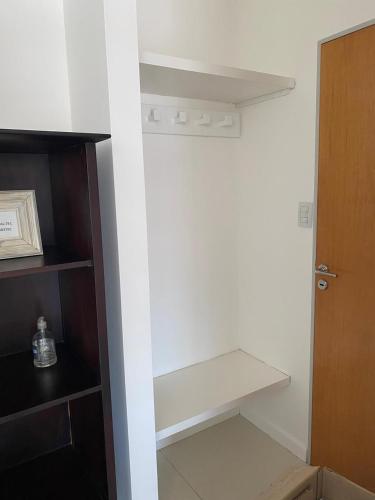 a closet with a white shelf and a door at Dpto 9 DE JULIO in Villa María