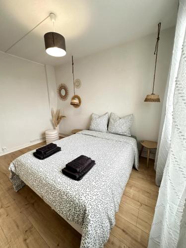 a bedroom with a bed with black towels on it at À Deux Pas de la Plage, Appartement 2 Chambres, 6 Pers in Berck-sur-Mer