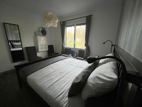 a bedroom with a large bed in front of a window at Chez Flo et Marc in Chouzy-sur-Cisse