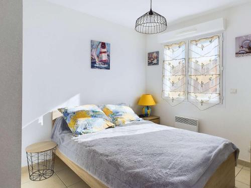 une chambre avec un lit avec des draps et des oreillers bleus dans l'établissement Maison T3 Climatisée à 450m de la Plage avec Terrasse et Garage - FR-1-423-115, au Grau-dʼAgde