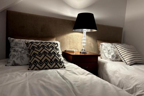a bedroom with two beds and a lamp on a night stand at Casal dos Frades in Fontainhas