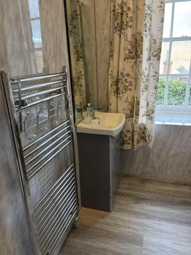 a bathroom with a sink and a window at City Centre En-Suite Room in Edinburgh