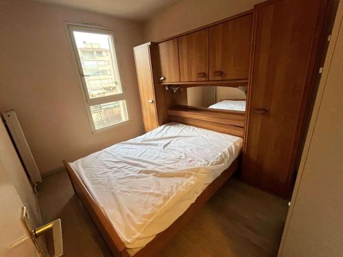 une petite chambre avec un lit et une fenêtre dans l'établissement Spacieux T3 avec piscine et parking près du port - FR-1-607-10, au Cap d'Agde