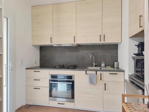 a kitchen with white cabinets and a stove top oven at Cabanon provençal in Rochefort-du-Gard