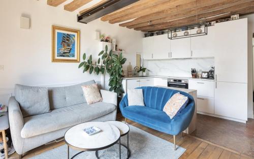 un salon avec un canapé et une chaise bleue dans l'établissement Typical Parisian Flat # Le Marais # Musée Picasso, à Paris