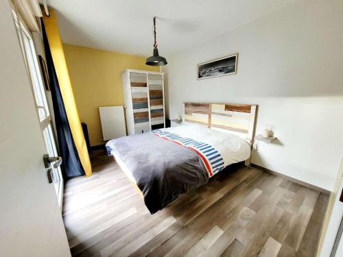 une chambre avec un lit et un parquet dans l'établissement Appartement lumineux près de la plage avec parking et WIFI - FR-1-675-42, à Wimereux