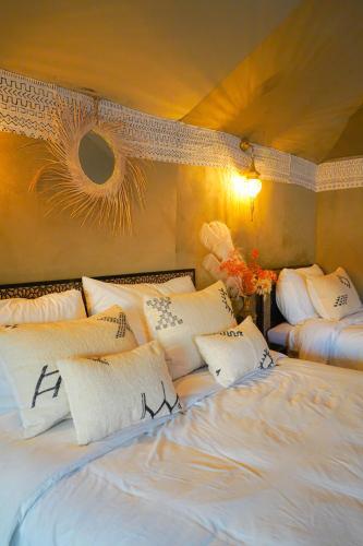 a bedroom with two beds with white pillows at Aladdin merzouga camp in Merzouga