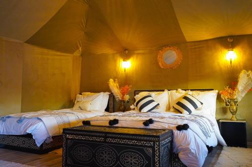 a bedroom with two beds in a tent at Aladdin merzouga camp in Merzouga