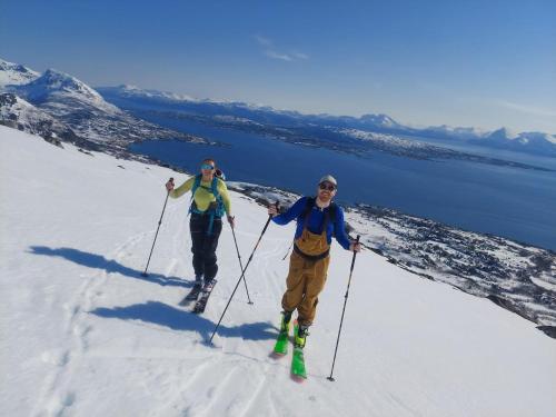 two people on skis on a snow covered slope at Senja 4 Summit in Torsken