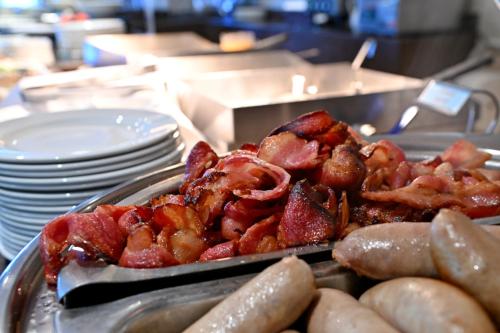 a tray of food with bacon and sausage on a table at Champagne Castle Hotel in Champagne Valley