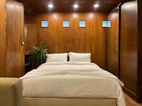 a large bed in a room with wooden walls at Luxury Studio Zamalek in Cairo