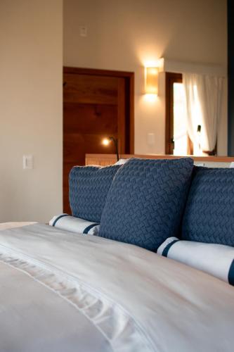a close up of a bed with blue pillows at Lavandas de Cunha Pousada Boutique in Cunha