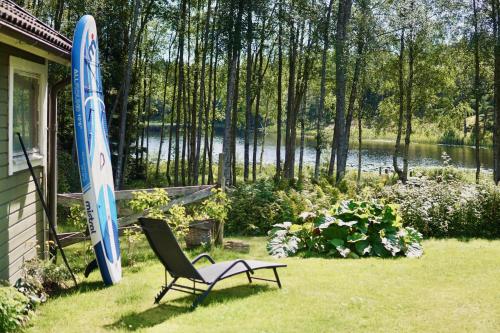 a chair sitting in the grass next to a house at Tiny House with a Stunning Lake View 30 Min from Gothenburg in Gråbo