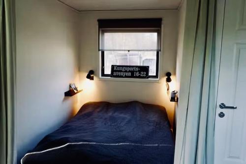 a bedroom with a bed and a window with a sign at Tiny House with a Stunning Lake View 30 Min from Gothenburg in Gråbo