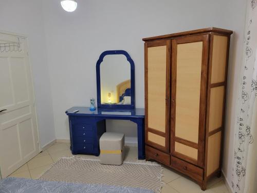 a blue dressing table with a mirror and a cabinet at Sassi Villa in Arkou