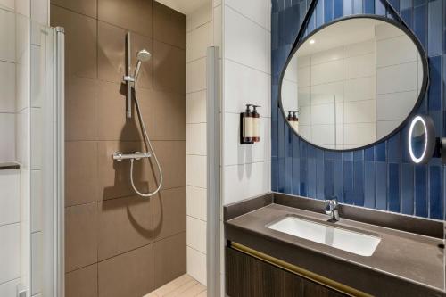 a bathroom with a sink and a mirror at Corendon Amsterdam New-West, a Tribute Portfolio Hotel in Amsterdam