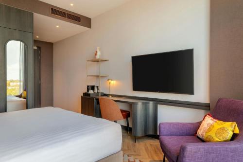 a hotel room with a bed and a tv at Corendon Amsterdam New-West, a Tribute Portfolio Hotel in Amsterdam