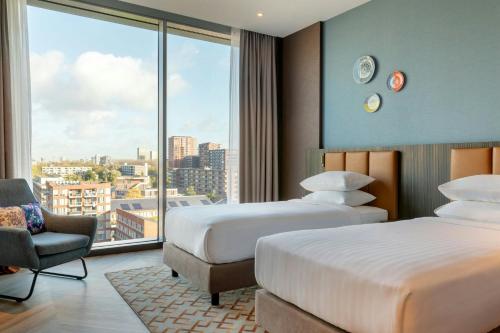 a hotel room with two beds and a window at Corendon Amsterdam New-West, a Tribute Portfolio Hotel in Amsterdam