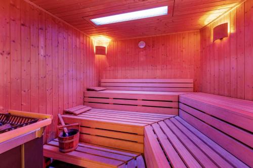 a wooden sauna with two benches and a light at Corendon Amsterdam New-West, a Tribute Portfolio Hotel in Amsterdam